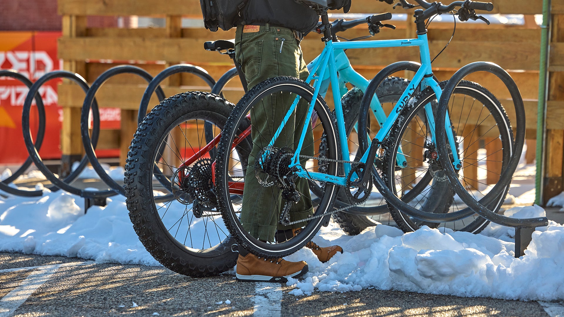 Cyclist parking bike with studded tires at snowy outdoor bike rack