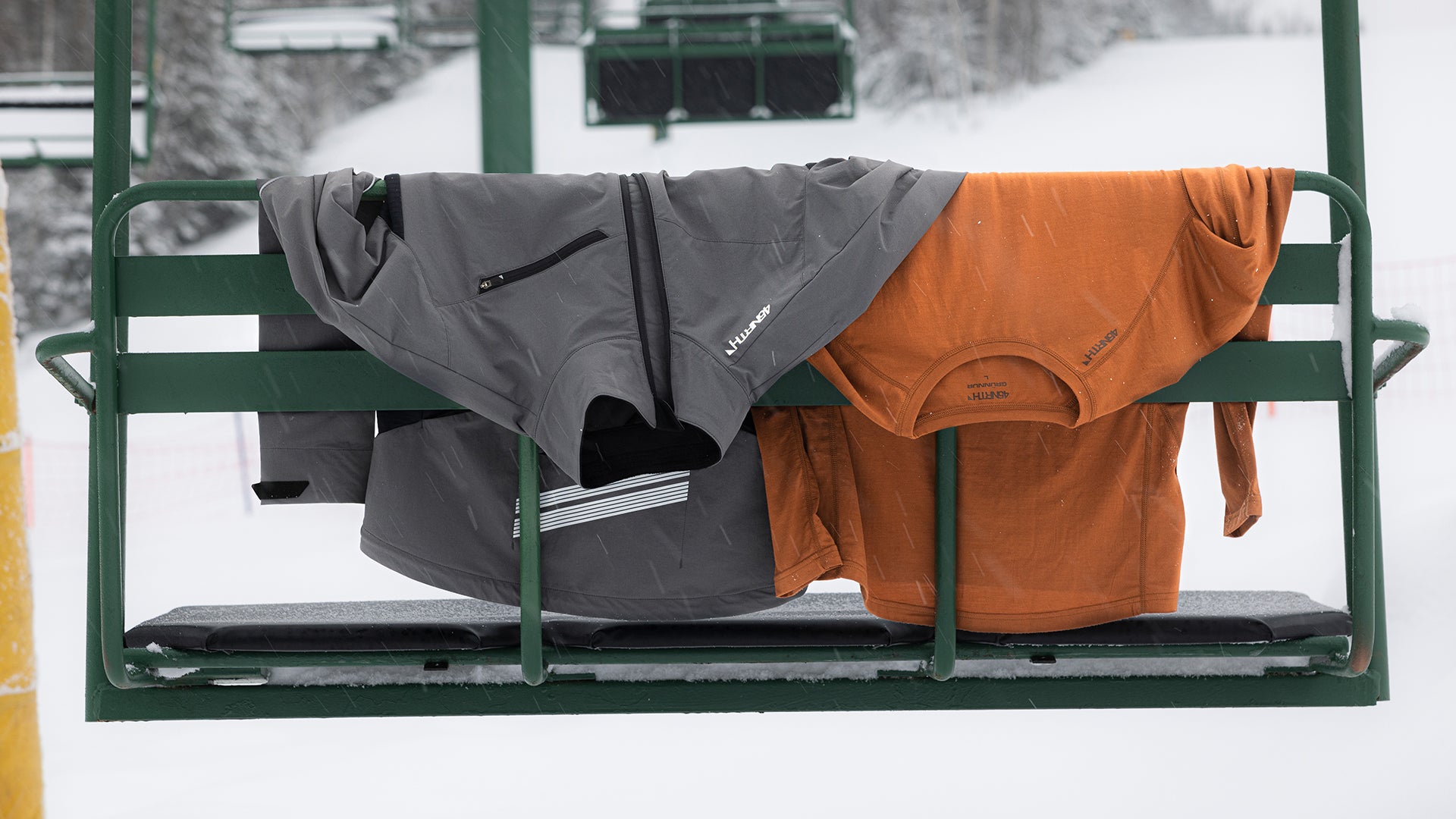 45NRTH Naughtvind Jacket and base layer draped over chairlift in winter